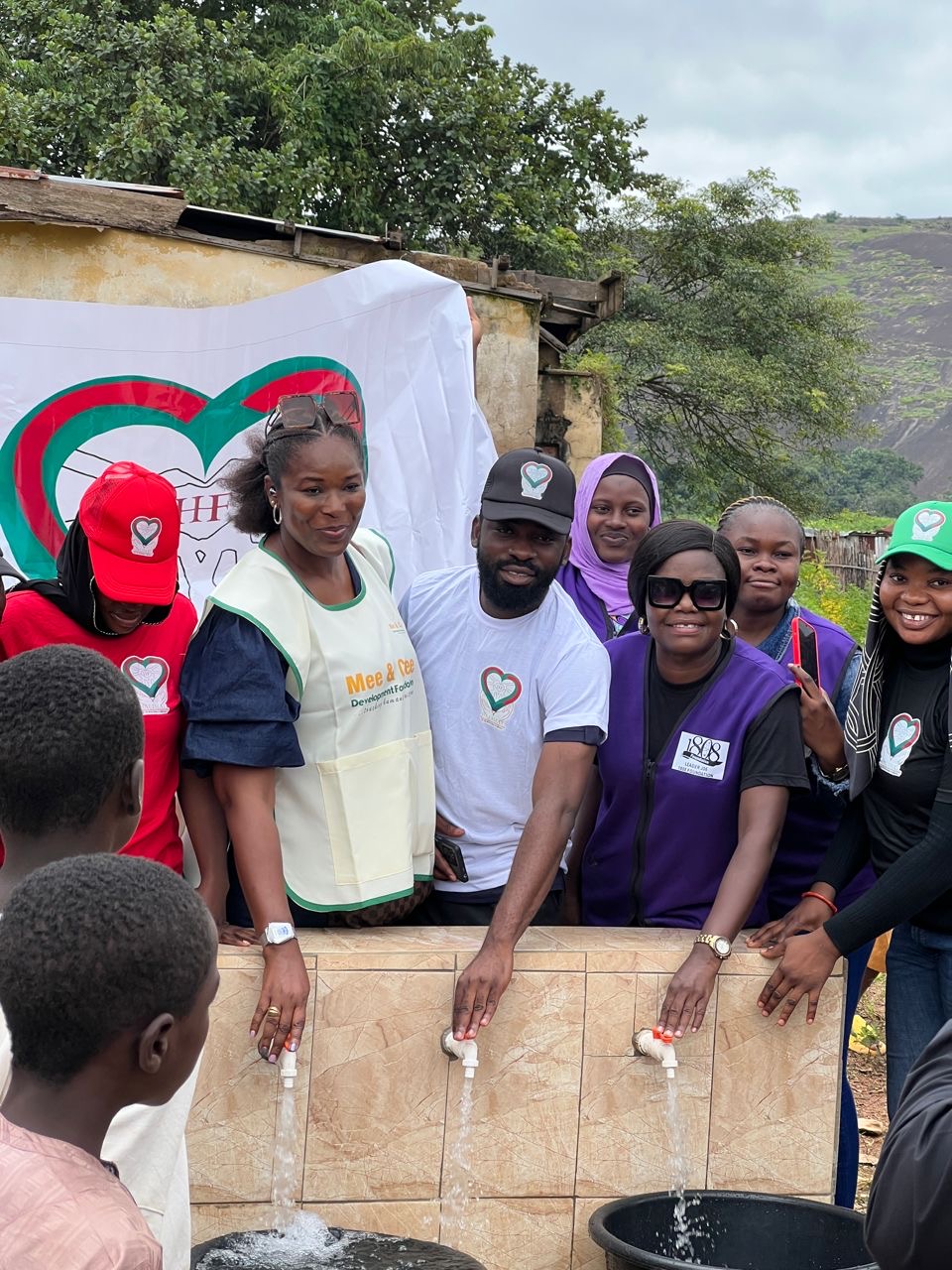 Foundation volunteers and community women standing at a newly completed community water point